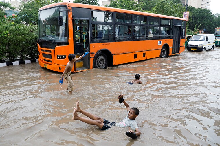 Children play on a flooded street after heavy rains in New Delhi, India, July 21, 2020