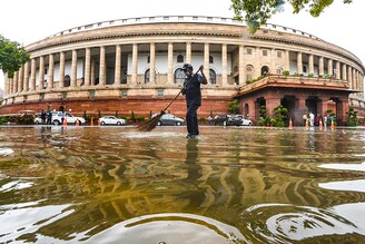 A worker cleans the premises at Parliament House after heavy rain on July 22, 2020 in New Delhi, India