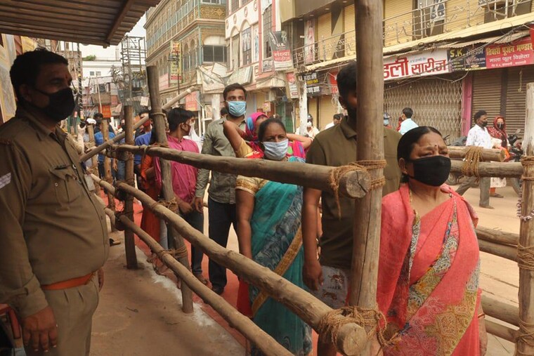 Devotees flouting social distancing as they wait to enter Baba Vishwanath temple on the fourth Monday of the month of Sawan on July 27, 2020 in Varanasi, India.
