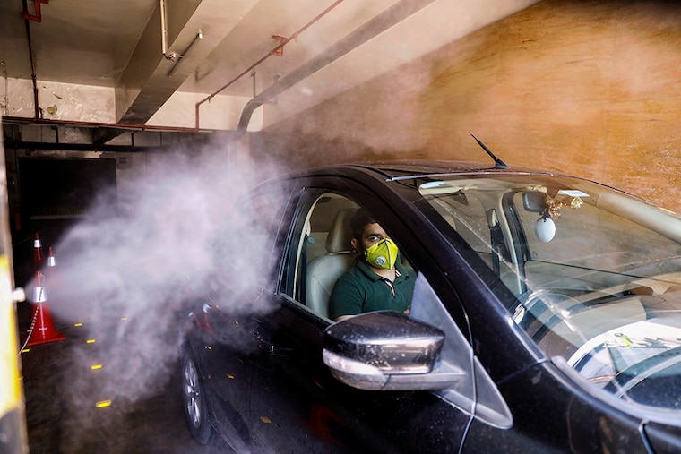 A car is sanitised at the entrance of a mall as part of a demonstrated sanitisation procedure by mall authorities ahead of its reopening during an extended nationwide lockdown to slow down the spread of the coronavirus disease (COVID-19), in New Delhi, India June 7, 2020