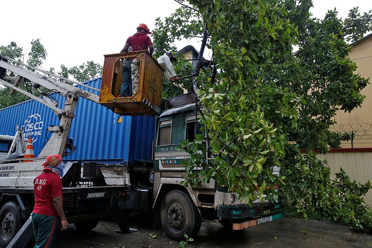 Rescue workers cut fallen tree branches after heavy winds caused by Cyclone Amphan, in Kolkata, India, May 20, 2020â£â£
