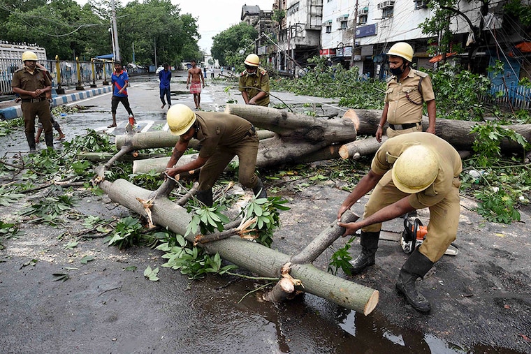Disaster Management teams clear the streets of uprooted trees at Esplanade after Cyclone Amphan on May 21, 2020 in Kolkata, India
