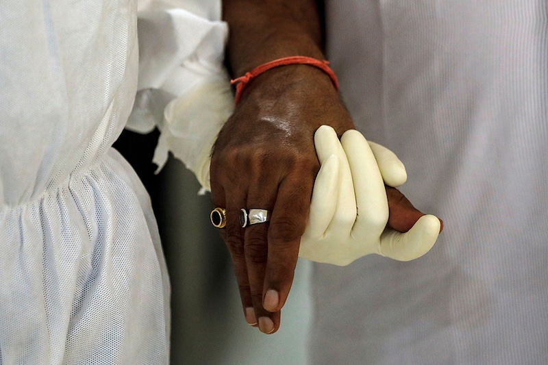 A medical worker wearing personal protective equipment (PPE) helps a patient suffering from the coronavirus disease (COVID-19), inside a high-dependency unit ward at the Max Smart Super Speciality Hospital in New Delhi, India, May 28, 2020.