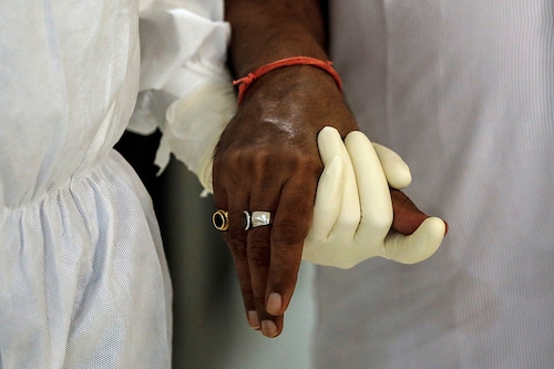 A medical worker wearing personal protective equipment (PPE) helps a patient suffering from the coronavirus disease (COVID-19), inside a high-dependency unit ward at the Max Smart Super Speciality Hospital in New Delhi, India, May 28, 2020.