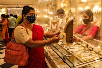 Woman looks at a gold necklace in a jewellery showroom during Dhanteras, a Hindu festival associated with Lakshmi, the goddess of wealth, amidst the spread of COVID-19 in Kolkata, India, November 13, 2020.