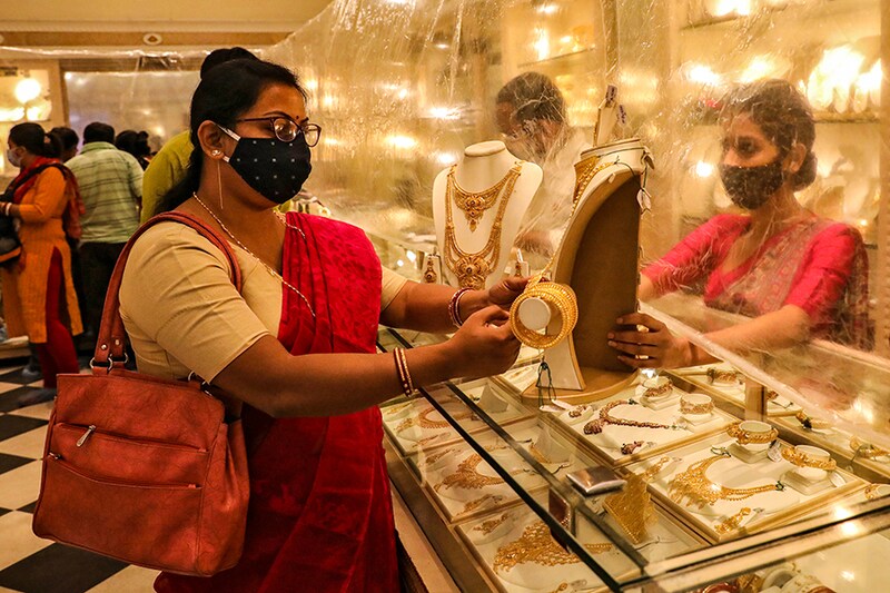 Woman looks at a gold necklace in a jewellery showroom during Dhanteras, a Hindu festival associated with Lakshmi, the goddess of wealth, amidst the spread of COVID-19 in Kolkata, India, November 13, 2020.
