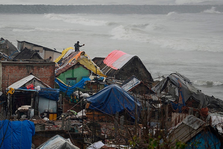 A resident fixes his roof during heavy rains as cyclone Nivar approaches the eastern Indian coast, in Chennai on November 24, 2020.