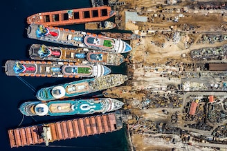 In this aerial view from a drone, five luxury cruise ships are seen being broken down for scrap metal at the Aliaga ship recycling port on October 02, 2020 in Izmir, Turkey. With the global coronavirus pandemic pushing the multi-billion dollar cruise industry into crisis, some cruise operators have been forced to cut losses and retire ships earlier than planned. The cruise industry has been one of the hardest hit industries with public confidence in cruise holidays plummeting after a series of outbreaks occurred on cruise liners as the pandemic spread. The crisis however has bolstered the years intake of ships at the Aliaga ship recycling port with business up thirty percent on the previous year.