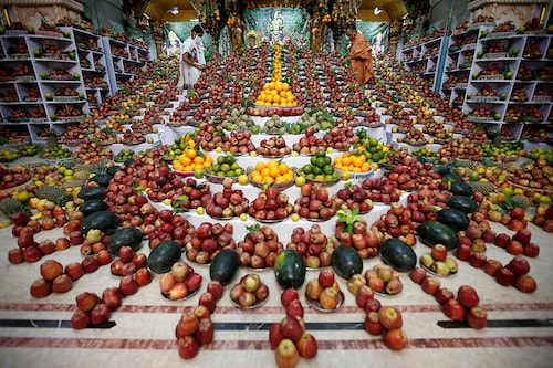 Priests arrange fruits kept inside a temple as offerings by Hindu devotees as part of a ritual to mark the Annakut festival in Ahmedabad, India, October 13, 2020. According to the priests, the fruits will be distributed among the coronavirus disease (COVID-19) affected believing it will cure them.