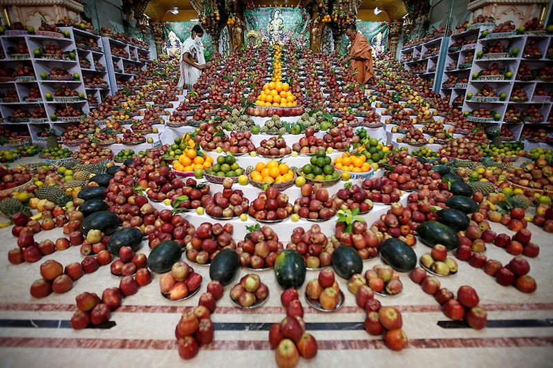 Priests arrange fruits kept inside a temple as offerings by Hindu devotees as part of a ritual to mark the Annakut festival in Ahmedabad, India, October 13, 2020. According to the priests, the fruits will be distributed among the coronavirus disease (COVID-19) affected believing it will cure them.