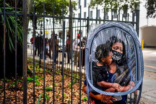Dana Clark, and her son 18 month old Mason, wait in line at City Hall as early voting begins for the upcoming presidential election in New Orleans, Louisiana, U.S., October 16, 2020.