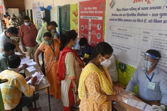 Voters queue to cast their votes for Bihar Legislative Council elections at Millar High School on October 22, 2020 in Patna, India.
