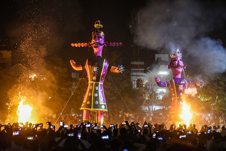 People watch and take pictures as effigies of Ravana, Meghnad, and Kumbhakarna burn during Dussehra celebrations by Shri Sanatan Dharam Sabha at New Colony Ground, on October 25, 2020 in Gurugram, India. People across the country have united in celebrating Dussehra. The underlying message on this day is the victory of truth over evil and to celebrate that effigies of the 10-headed Ravana is burnt