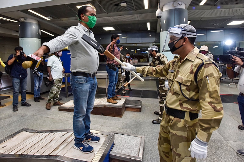 A security official wearing a face-shield frisks a journalist during a press preview to show the preparedness of Delhi Metro to resume service amid coronavirus outbreak, at Rajiv Chowk Metro Station, on September 3, 2020 in New Delhi, India. Delhi Metro will re-open its services in a phased manner from September 7.