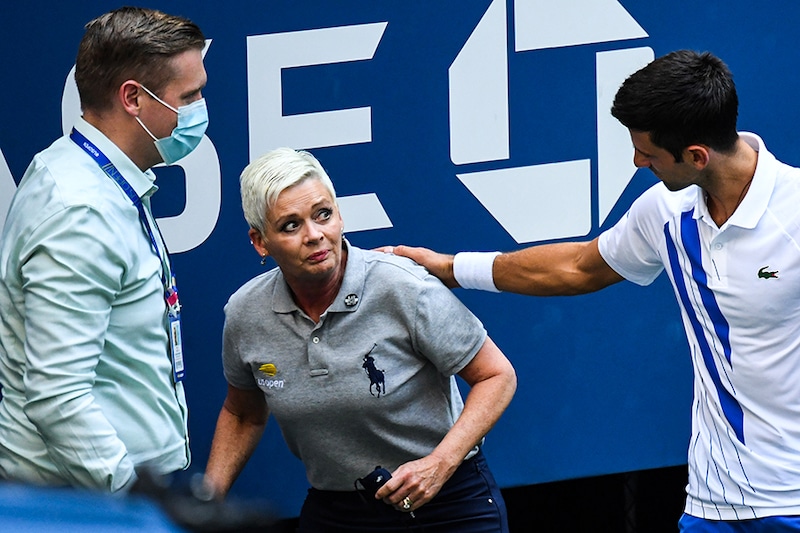 World No. 1 tennis player, according to Association of Tennis Professionals, Novak Djokovic and a tournament official tend to a linesperson who was struck with a ball by Djokovic against Pablo Carreno Busta of Spain (not pictured) on day seven of the 2020 U.S. Open tennis tournament at USTA Billie Jean King National Tennis Center. Djokovic was defaulted from the match.