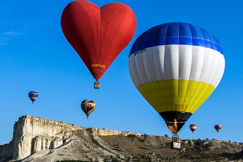 Hot air balloons in flight during the Crimean Sky Balloon Festival held near the White Rock (Aq Qaya) in central Crimea to mark the 75th anniversary of the victory in World War II.