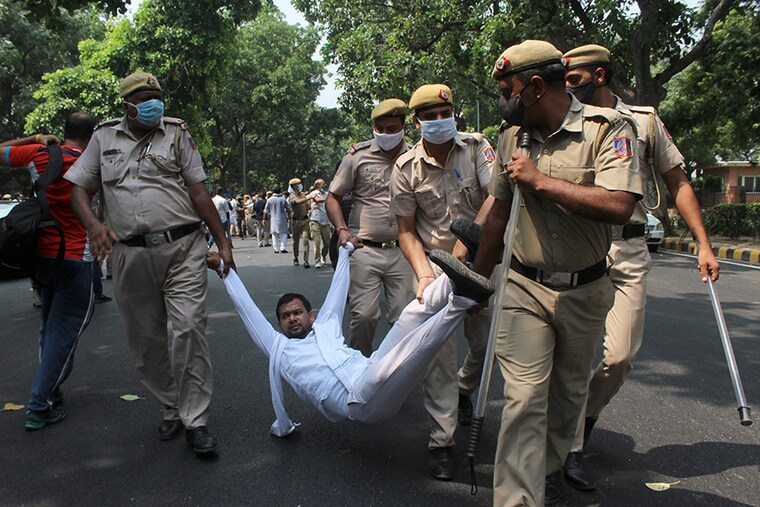 Delhi Police personnel detain Congress workers during a protest held by Delhi Pradesh Congress Committee (DPCC) against the Central government"s agricultural reforms bills at Rajendra Prasad Road on September 21, 2020 in New Delhi. The Centre introduced three Bills on food and agriculture reforms: The Farmers" Produce Trade and Commerce (Promotion and Facilitation) Bill, and The Farmers Empowerment and Protection Agreement on Price Assurance and Farm Services Bill, amidst vehement protest from the opposition parties and the farmers groups.