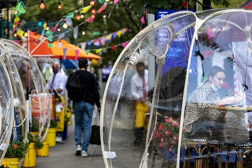 A woman sits outside Cafe Du Soliel under bubble tents following the outbreak of the coronavirus disease (COVID-19) in the Manhattan borough of New York City, New York, U.S., September 23, 2020.