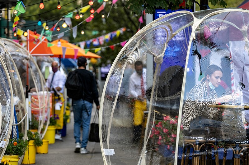 A woman sits outside Cafe Du Soliel under bubble tents following the outbreak of the coronavirus disease (COVID-19) in the Manhattan borough of New York City, New York, U.S., September 23, 2020.