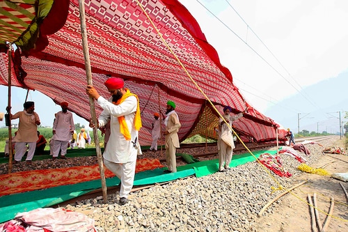 Farmers erect a temporary shade on railway tracks to take shelter from the sun as they block the rail tracks during a protest against farm bills passed by India"s parliament, in Devi Dasspura village on the outskirts of Amritsar, India, September 24, 2020.