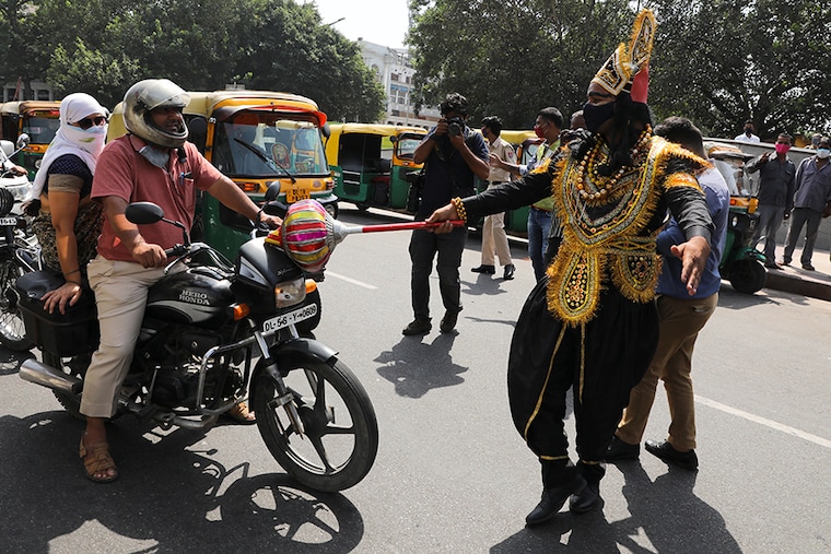 A volunteer of District Magistrate (DM) office dressed as Yamraj, or Hindu God of death, stops people for not wearing masks, amidst the spread of the coronavirus (COVID-19) disease, in New Delhi, India, September 28, 2020.