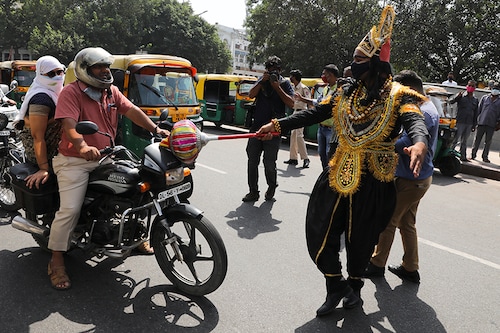 A volunteer of District Magistrate (DM) office dressed as Yamraj, or Hindu God of death, stops people for not wearing masks, amidst the spread of the coronavirus (COVID-19) disease, in New Delhi, India, September 28, 2020.