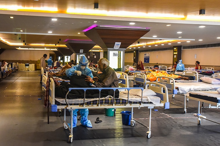 Medical staff in PPE coveralls attend to patients housed in the Shehnai Banquet Hall Covid-19 care centre attached to LNJP Hospital on April 15, 2021 in New Delhi, India. In what is called the fourth wave of COVID-19 in Delhi, the infection caseload of Delhi has reached 7,67,438 with 50,736 active cases. As many as 11,540 people have died due to the virus in Delhi so far. In the previous peak in November 2020, 8,500 cases were reported in a day in Delhi.