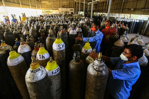 Workers prepare to fill medical oxygen cylinders for hospital use on Covid-19 coronavirus patients on the outskirts of Jabalpur on April 18, 2021. Oxygen has become an emergency in most of the states where numbers of Covid-19 cases are rising exponentially.