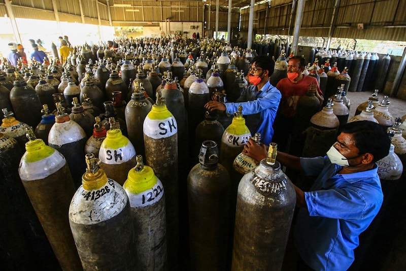 Workers prepare to fill medical oxygen cylinders for hospital use on Covid-19 coronavirus patients on the outskirts of Jabalpur on April 18, 2021. Oxygen has become an emergency in most of the states where numbers of Covid-19 cases are rising exponentially.