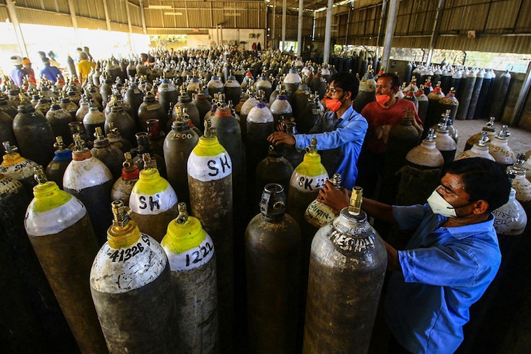 Workers prepare to fill medical oxygen cylinders for hospital use on Covid-19 coronavirus patients on the outskirts of Jabalpur on April 18, 2021. Oxygen has become an emergency in most of the states where numbers of Covid-19 cases are rising exponentially.