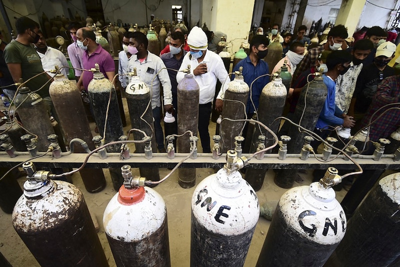 People refill medical oxygen cylinders for Covid-19 coronavirus patients at an oxygen refill station in Allahabad on April 20, 2021.
