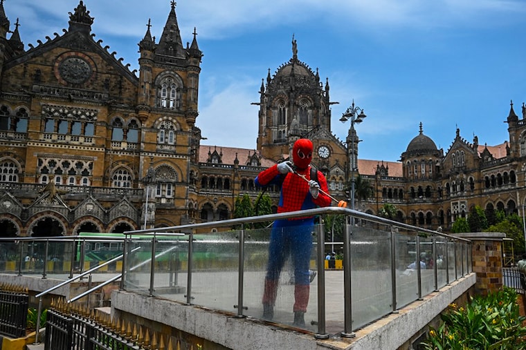 Ashok Kurmi, a pharmaceutical company employee, dressed as Spiderman sprays disinfectant outside the Chhatrapati Shivaji Maharaj terminus railway station in Mumbai on April 21, 2021.