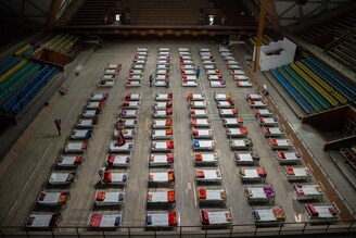 Rows of beds are placed inside an indoor sports stadium turned COVID-19 isolation centre in Srinagar. Jammu and Kashmir reported 3,164 positive cases, the highest ever since the outbreak of Covid-19 pandemic last year, pushing the number of active cases to 22,283 which otherwise were less than 600 around a month before. A 20-year-old woman was reported among the twenty-five deaths in J&K in the last 24 hours taking the death toll to 2,197.