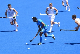 India"s Hardik Singh (C) carries the ball during the men"s semi-final match of the Tokyo 2020 Olympic Games field hockey competition against Belgium at the Oi Hockey Stadium in Tokyo, on August 3, 2021.
