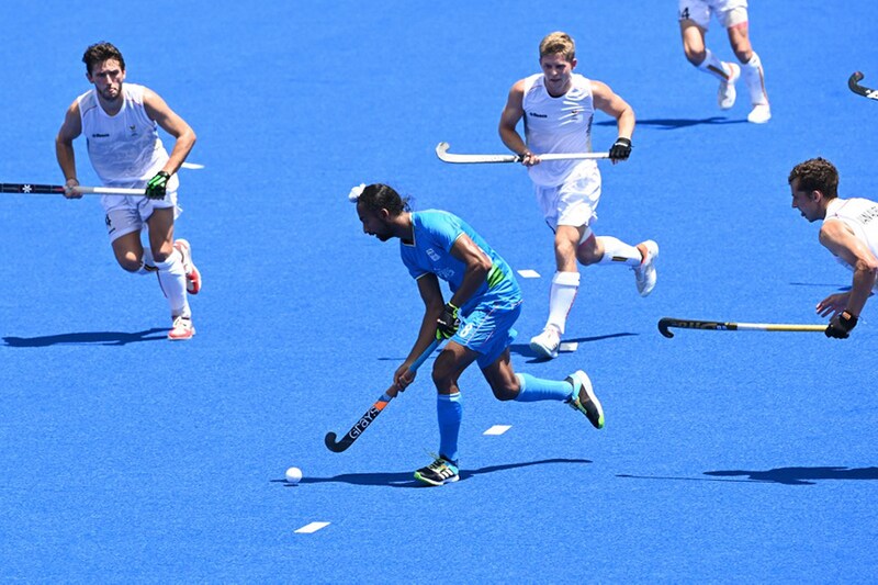 India"s Hardik Singh (C) carries the ball during the men"s semi-final match of the Tokyo 2020 Olympic Games field hockey competition against Belgium at the Oi Hockey Stadium in Tokyo, on August 3, 2021.