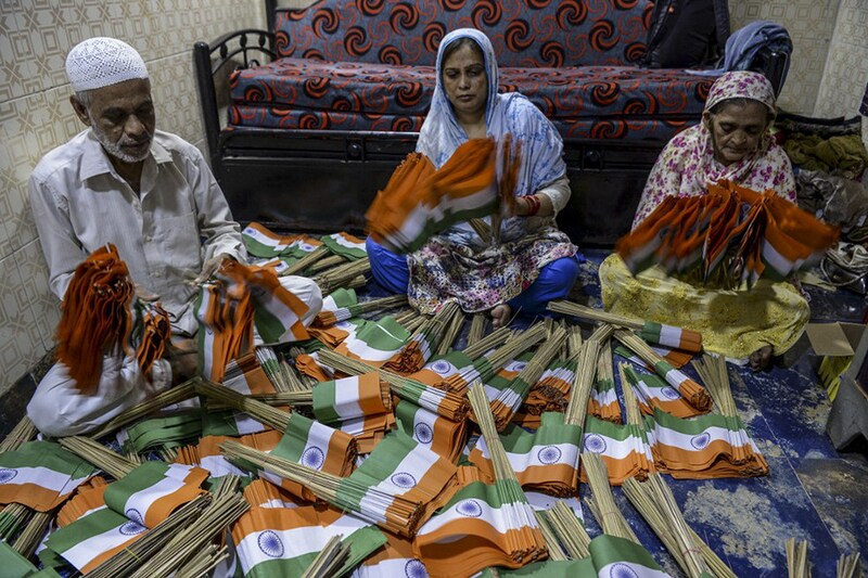 Flagmaker Nissar Ahmad (L), with Farzana Ahmad (C) and Saeeda Banu make Indian flags and pack them in bundles for sale ahead of the India"s 75th Independence Day celebrations in Mumbai on August 9, 2021.