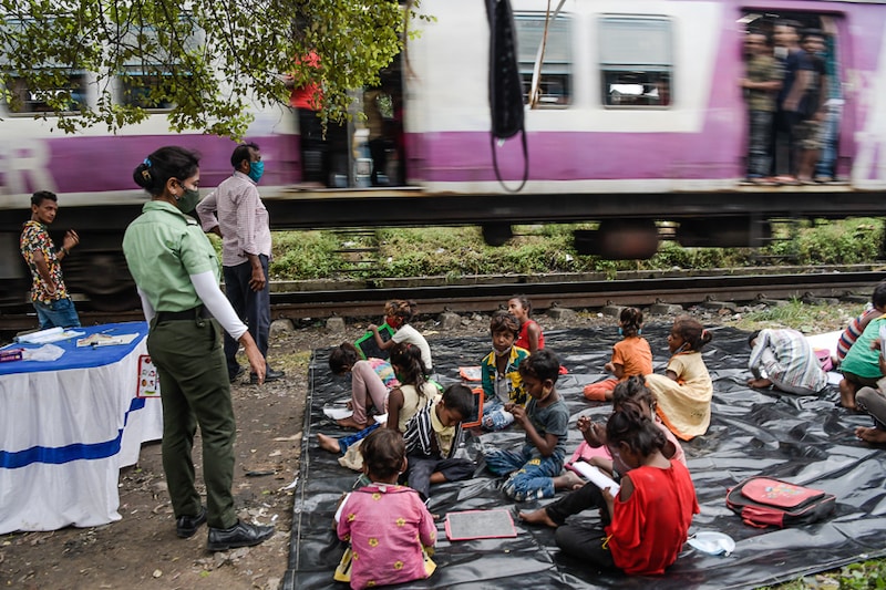 A traffic guard volunteer teaches underprivileged children at a slum alongside a railway track in Kolkata. As educational institutions in India are closed for over a year now, the South West traffic guards have organised special interactive classes for these children who have no access to online classes.