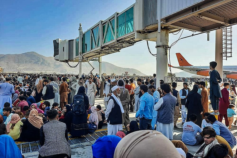 Afghan citizens crowd at the tarmac of the Kabul airport to flee the country as the Taliban took control of Afghanistan after Ashraf Ghani resigned as president and fled the country.