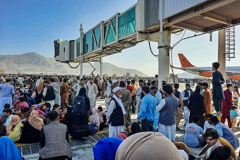 Afghan citizens crowd at the tarmac of the Kabul airport to flee the country as the Taliban took control of Afghanistan after Ashraf Ghani resigned as president and fled the country.