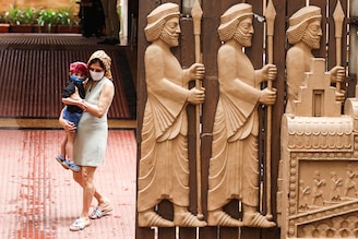 A Parsi woman and her child step out of a fire temple adorned with carvings of priests on Persian New Year, also known as "Jamshedji Navroz" in Mumbai, India, August 16, 2021. Zoroastrians migrated to India, settling in Gujarat & other states in India, upon fleeing from Islamic persecution of Persia.