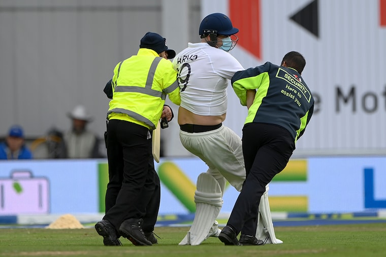 A pitch invader dressed as a batsman is escorted off the field during day three of the Third Test Match between England and India at Emerald Headingley Stadium on August 27, 2021 in Leeds, England.