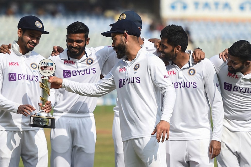 India"s Virat Kohli (C) holds the trophy after winning the fourth day of the second Test cricket match between India and New Zealand at the Wankhede Stadium in Mumbai on December 6, 2021.