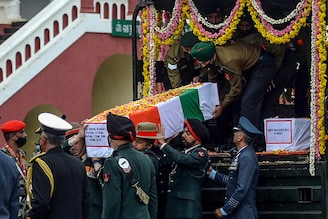 Army officers and soldiers carry the coffin containing the mortal remains of Indian defence chief General Bipin Rawat who lost his life along with 13 others a day earlier in a helicopter crash in Coonoor during a military funeral ceremony at the Madras regimental Center in Wellington, Tamil Nadu, on December 9, 2021.