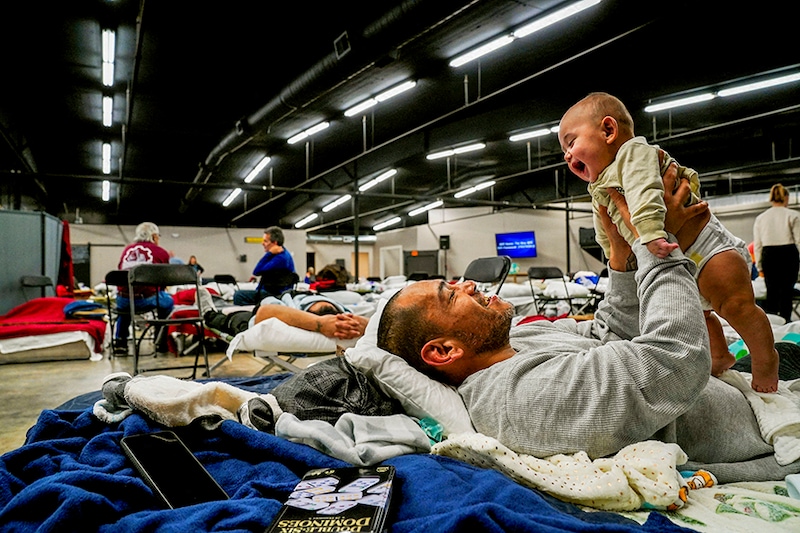 Anthony Vasquez, 42, plays with his four month-old son Michael inside a makeshift shelter which houses people who lost their homes after a devastating outbreak of tornadoes ripped through several U.S. states in Wingo, Kentucky, U.S., December 13, 2021.