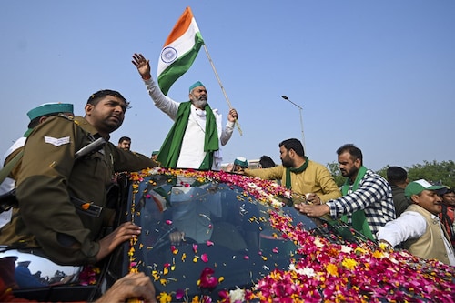 Bharatiya Kisan Union leader Rakesh Tikait waves to supporters leaving the protest site at the Delhi-Uttar Pradesh state border in Ghazipur on December 15, 2021, as Indian farmers formally ended year-long mass protests after the Centre abandoned its push for agricultural reforms.