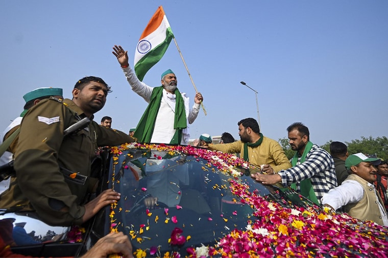 Bharatiya Kisan Union leader Rakesh Tikait waves to supporters leaving the protest site at the Delhi-Uttar Pradesh state border in Ghazipur on December 15, 2021, as Indian farmers formally ended year-long mass protests after the Centre abandoned its push for agricultural reforms.