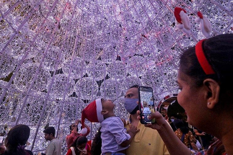 People take pictures inside an illuminated Christmas tree at a mall during Christmas celebrations in Mumbai, India, December 25, 2021.