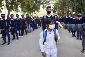 A student undergoes thermal screening before entering Model Senior Secondary School Urban Estate at Sector 4, on February 1, 2021 in Gurugram, India. Schools in Gurugram reopened for 6th to 8th standard on Monday.