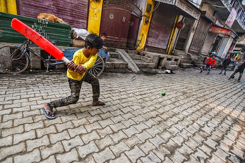 Children playing cricket on the street as schools are closed due to farmers" protest at the Tikri border on February 4, 2021 in New Delhi, India. Security at the borders, where farmers have been camping for the past two and half months to agitate against Centre"s agricultural legislation, was stepped up after thousands of protesters stormed the national capital during their tractor rally and clashes broke out between them and the police in which one farmer died while several policemen were injured.
