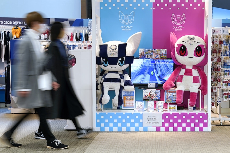 Pedestrians walk past a Tokyo 2020 Olympic Games official shop in Tokyo, Japan, on Thursday, February 4, 2021. The set of rules published this week by organizers of the delayed Tokyo Olympics offers an early glance at measures to prevent the spread of the Covid-19 pathogen.
